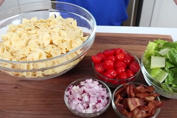 A tésztasaláta hozzávalói: tészta, hagyma, paradicsom, saláta és fűszerek